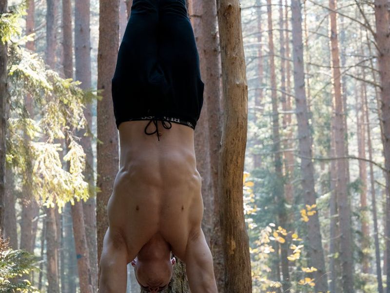 Man performing a controlled bodyweight exercise in a minimalist space.